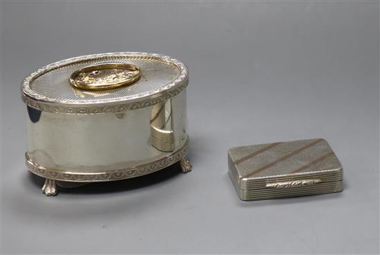 A silver oval table musical box and a Garrard & Co silver and gold pill box